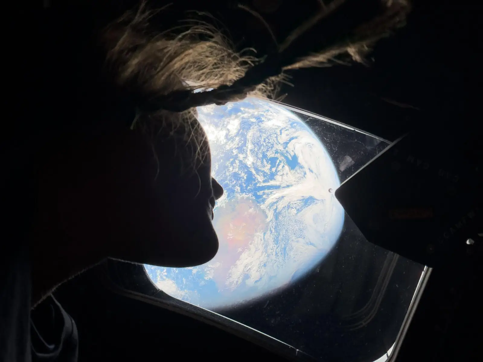 L'astronauta Christina Koch guarda la Terra dal finestrino della capsula Orion durante la missione Artemis II, aprile 2026